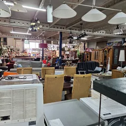 Winkelvloer van kringloopwinkel met diverse meubels, lampen en huishoudartikelen uitgestald