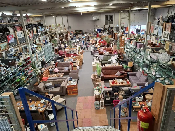 Overzicht van de winkelhal met banken, meubels en huishoudelijke artikelen uitgestald op de vloer