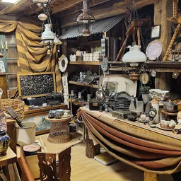 Verzameling tweedehands huishoudartikelen, lampen, servies, meubels en decoraties uitgestald in een kringloopwinkel