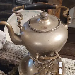 Zilveren theepot met decoratieve handvatten en knop op deksel