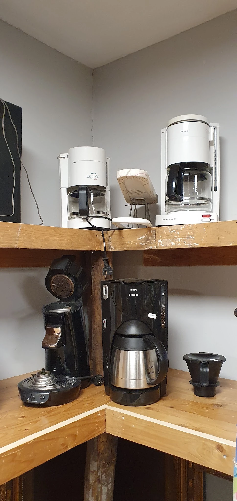 Plank met tweedehands keukenapparaten: koffiezetapparaten, koptelefoon en andere huishoudelijke apparaten