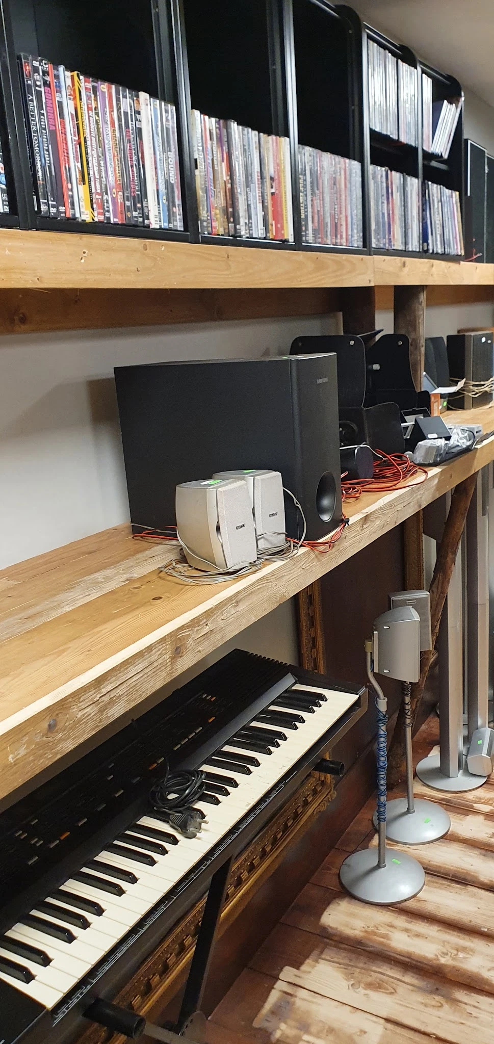 Houten werkblad met computerrandapparatuur, waaronder speakers, monitors en kabels