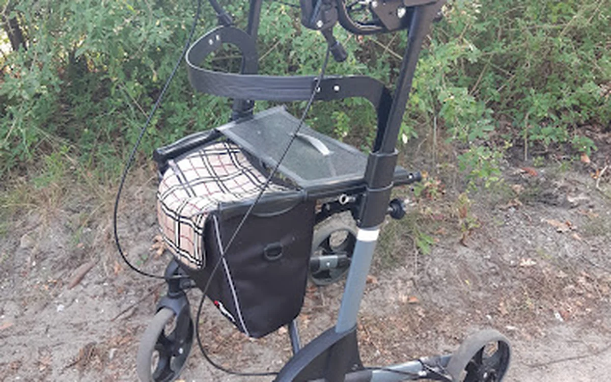 Elektrische scooter of loopfiets met zwarte zitting en handvat, tegen groen gras