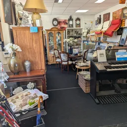 Winkelbinnenkant met meubels, muziekinstrument, klokken, servies en diverse decoratieve items