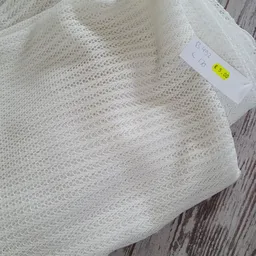 Witte gebreide trui met prijs etiket op houten ondergrond