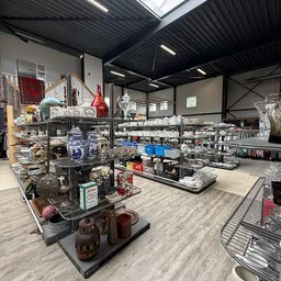 Winkelinterieur met stellingen vol serviesgoed, glazen en decoratieve artikelen