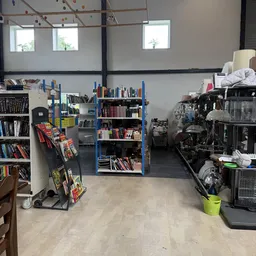 Winkelvloer met boekenrekken, stellingen met diverse tweedehands spullen en opbergruimtes vol goederen