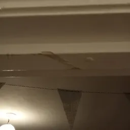 Zeer donkere, onduidelijke foto van wat lijkt een plafond of bovenkant van ruimte