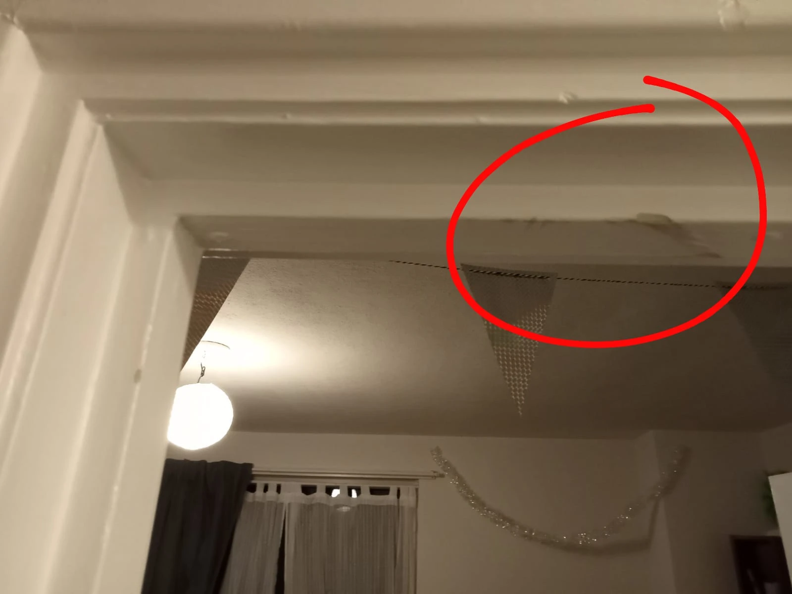 Plafond en muur van een winkelruimte met een lamp en zichtbare schade of vervuiling