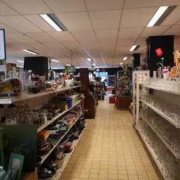 Winkelvloer van kringloopwinkel met stellingen, toonbanken en uiteenlopende tweedehands spullen