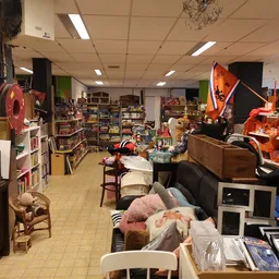Binnenaanzicht van kringloopwinkel met meubels, huishoudartikelen en verschillende spullen op stellingen