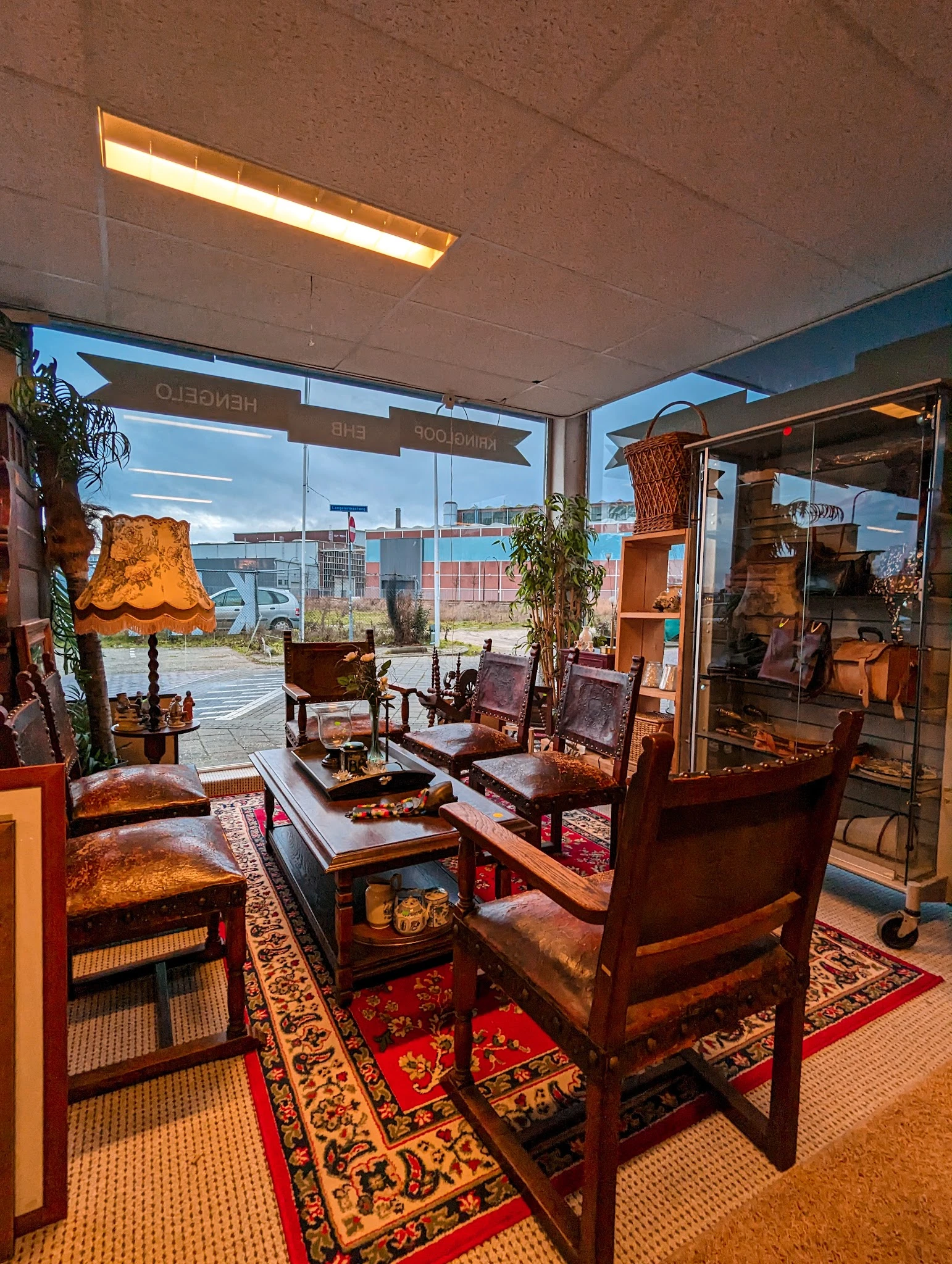 Vintage woonkamer met houten meubels, rode stoelen en lampen bij grote ramen met uitzicht