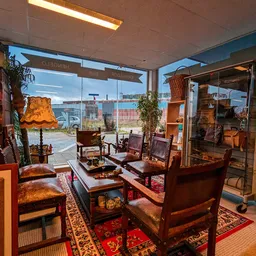 Vintage woonkamer met houten meubels, rode stoelen en lampen bij grote ramen met uitzicht