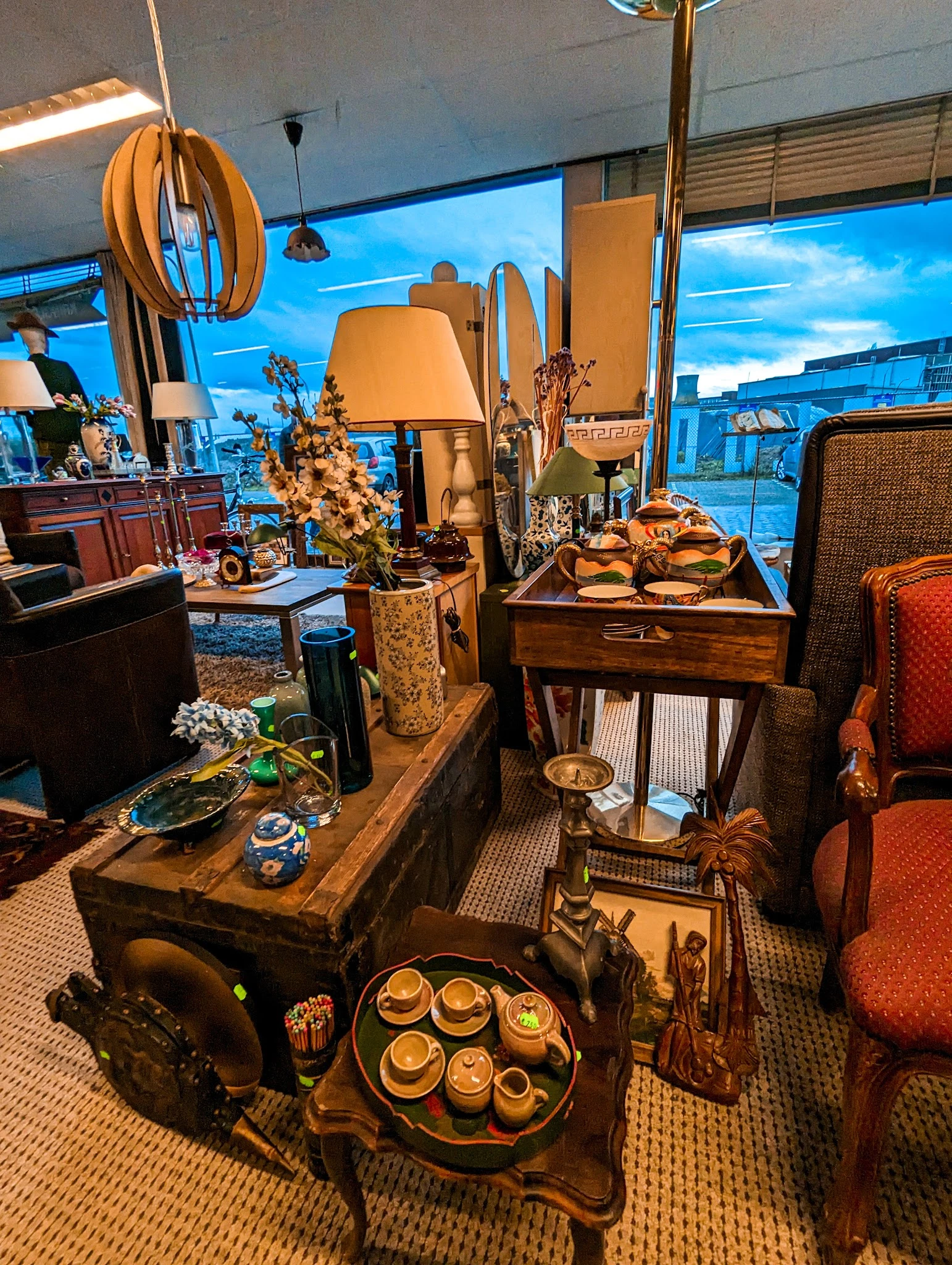 Interieur met uitgestalde meubels en decoratieve artikelen: lampen, stoelen, tafels en accessoires in vintage/klassieke stijl