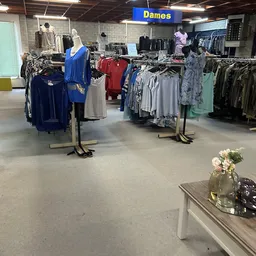 Winkelvloer met kledingrekken en uitgestalde kleding in verschillende kleuren