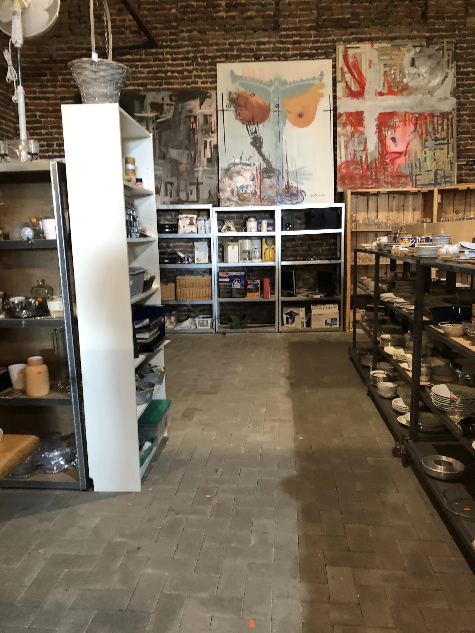 Winkelvloer met stellingen en kasten vol met tweedehands artikelen en huishoudspullen