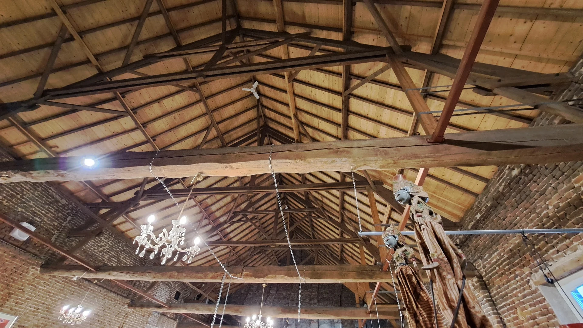 Houten zolderruimte met dakconstructie, balken en hanglampen
