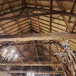 Houten zolderruimte met dakconstructie, balken en hanglampen