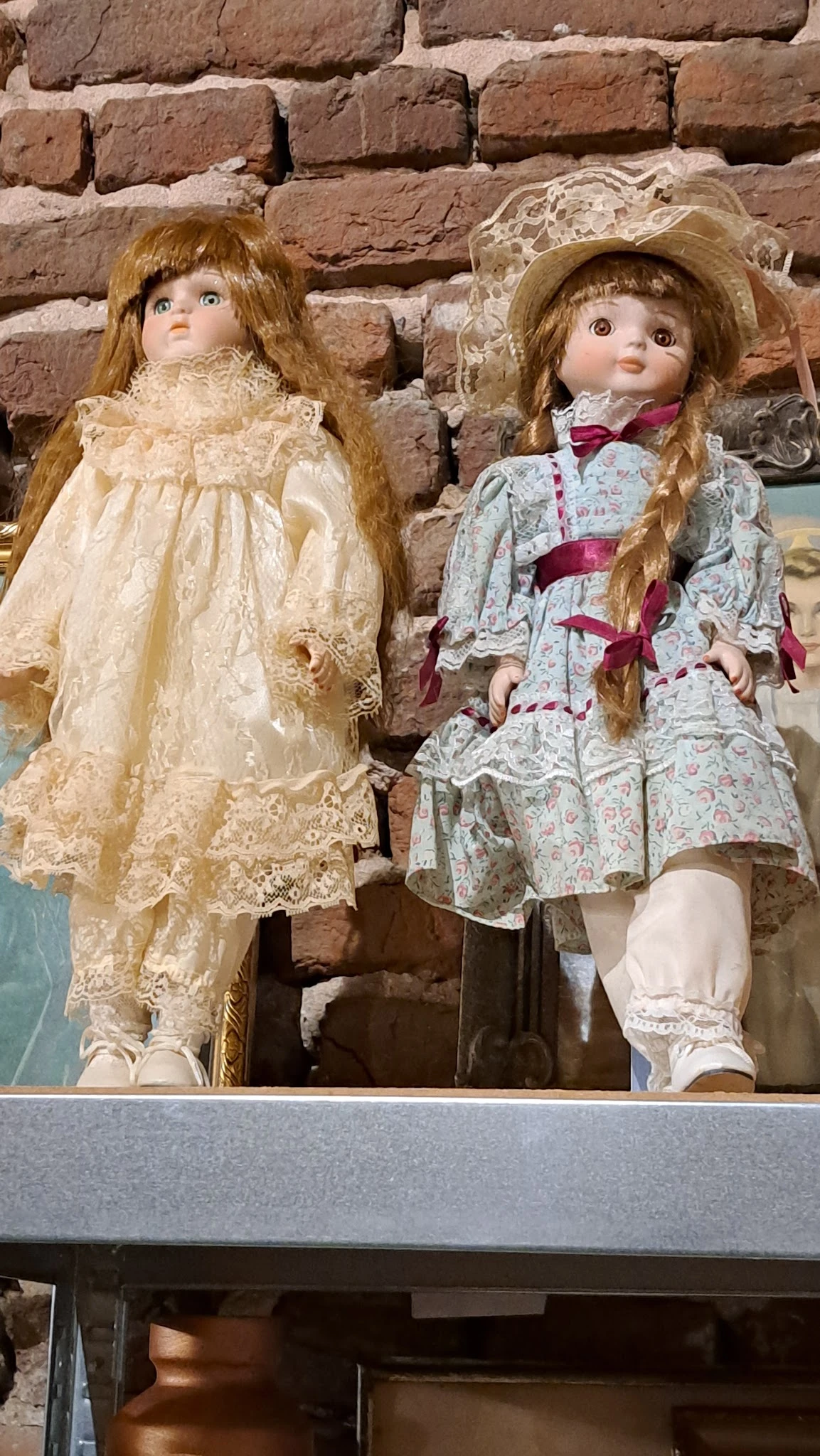 Tweedehands kinderjurken op hangers, waaronder een creme kanten jurk en een gebloemde jurk met roze strik.