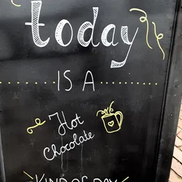Krijtbord met tekst 'Today is a Hot Chocolate' met decoratieve tekening van een mok