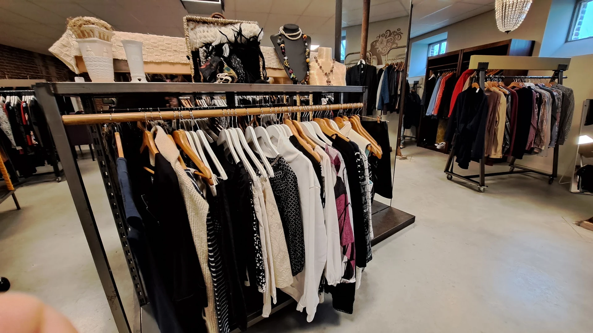 Kledingrekken met tweedehands dames- en herenkleding in verschillende kleuren en maten