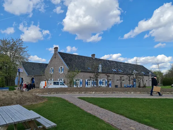 Voorkant van stenen kringloopwinkel aan Naborchweg met ingang en blauwe decoratie