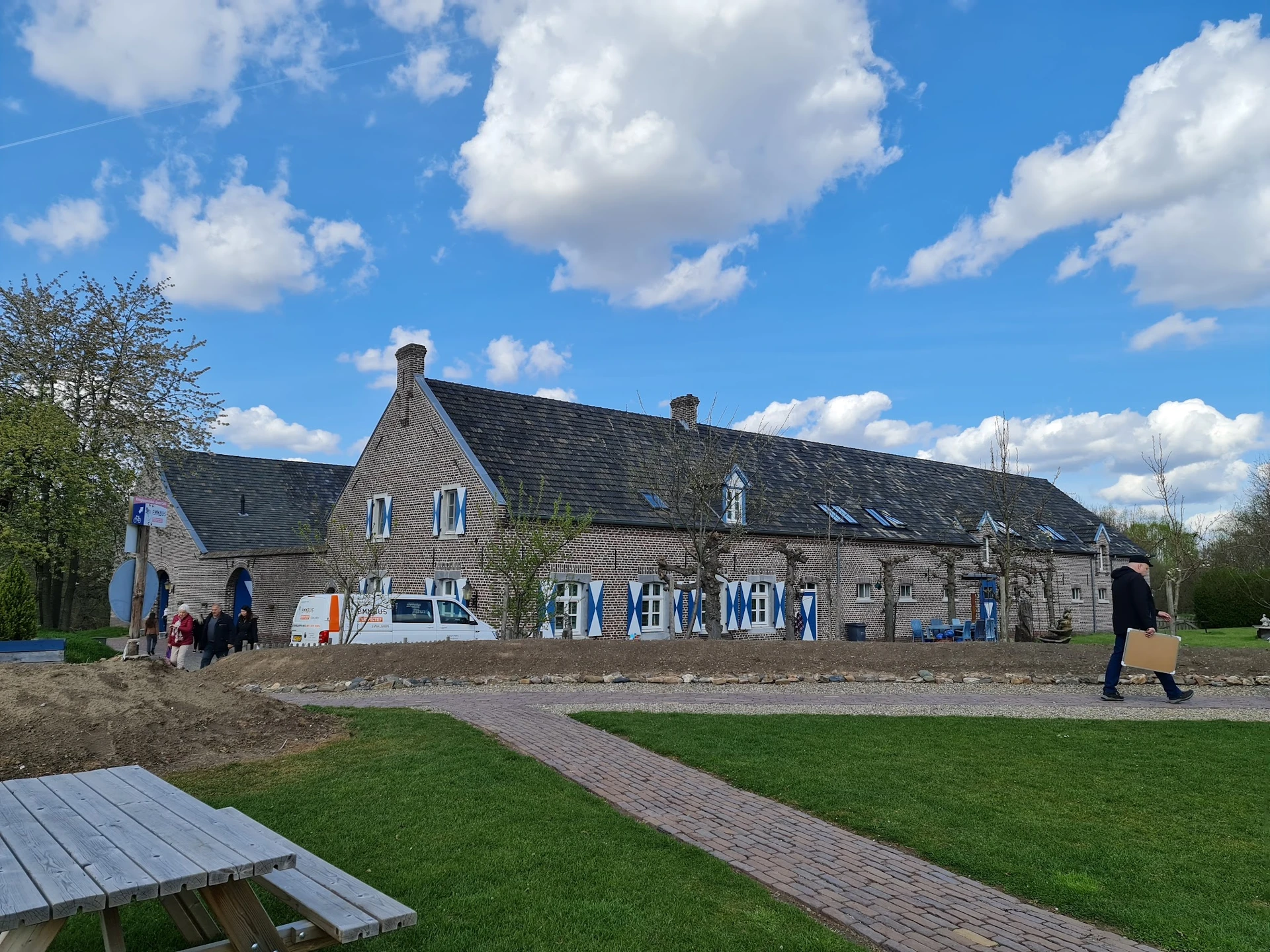 Voorkant van stenen kringloopwinkel aan Naborchweg met ingang en blauwe decoratie