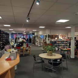 Winkelvloer van kringloopwinkel met diverse afdelingen, stellingen, tafels en verschillende tweedehands artikelen