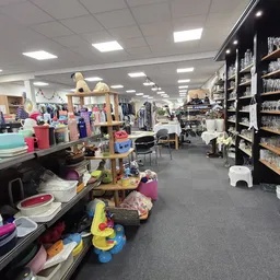 Winkelvloer van kringloopwinkel met verschillende afdelingen: kleding, huishoudartikelen, servies en decoratie