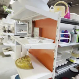 Witte kunststof opbergkisten en bakjes op planken met oranje achterwand in de winkel