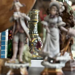 Close-up van een glazen fles met geel/amberachtige vloeistof en rood accent, op onscherpe achtergrond met beeldjes