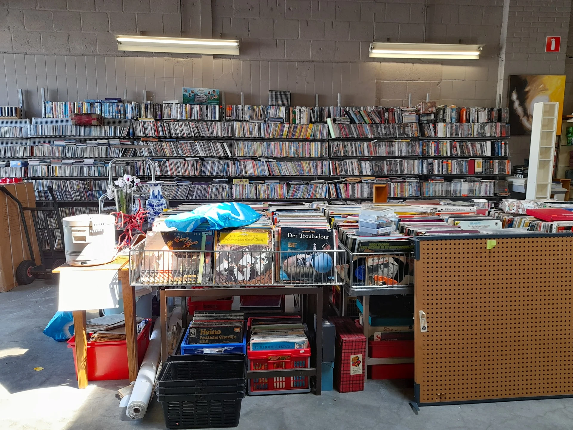 Uitgestalde tweedehands spullen inclusief dvd's, boeken, huishoudartikelen en meubels in kringloopwinkel