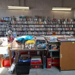 Uitgestalde tweedehands spullen inclusief dvd's, boeken, huishoudartikelen en meubels in kringloopwinkel