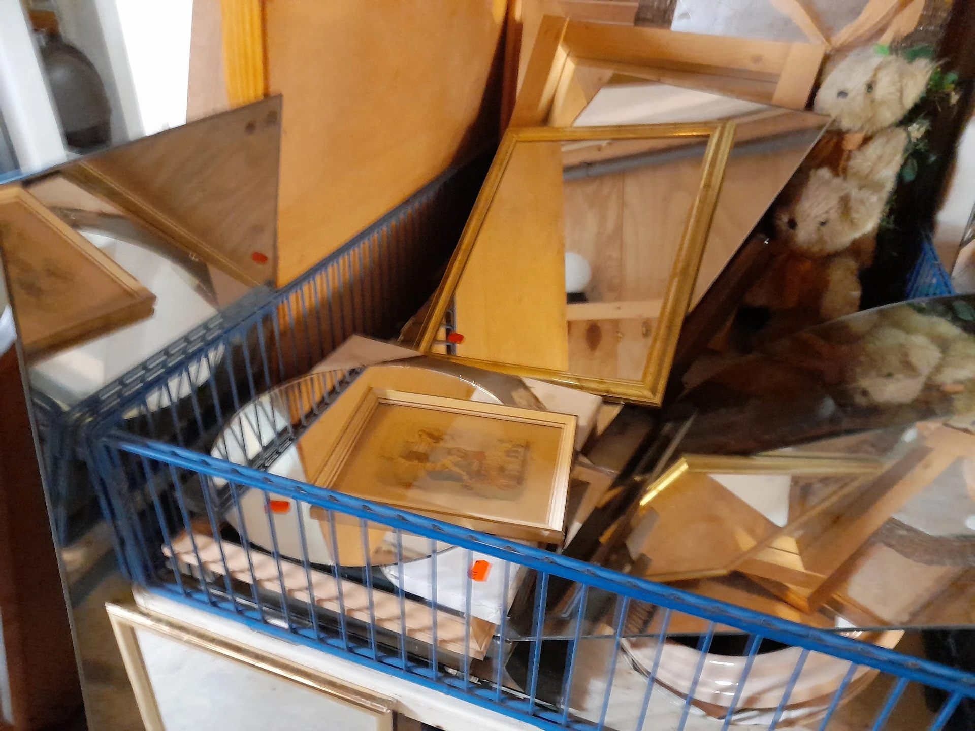 Blauwe winkelwagen met houten kasten en meubels in kringloopwinkel