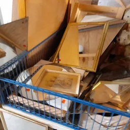 Blauwe winkelwagen met houten kasten en meubels in kringloopwinkel