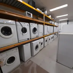 Stellingen met witgoedapparaten, voornamelijk wasmachines en drogers in verschillende maten