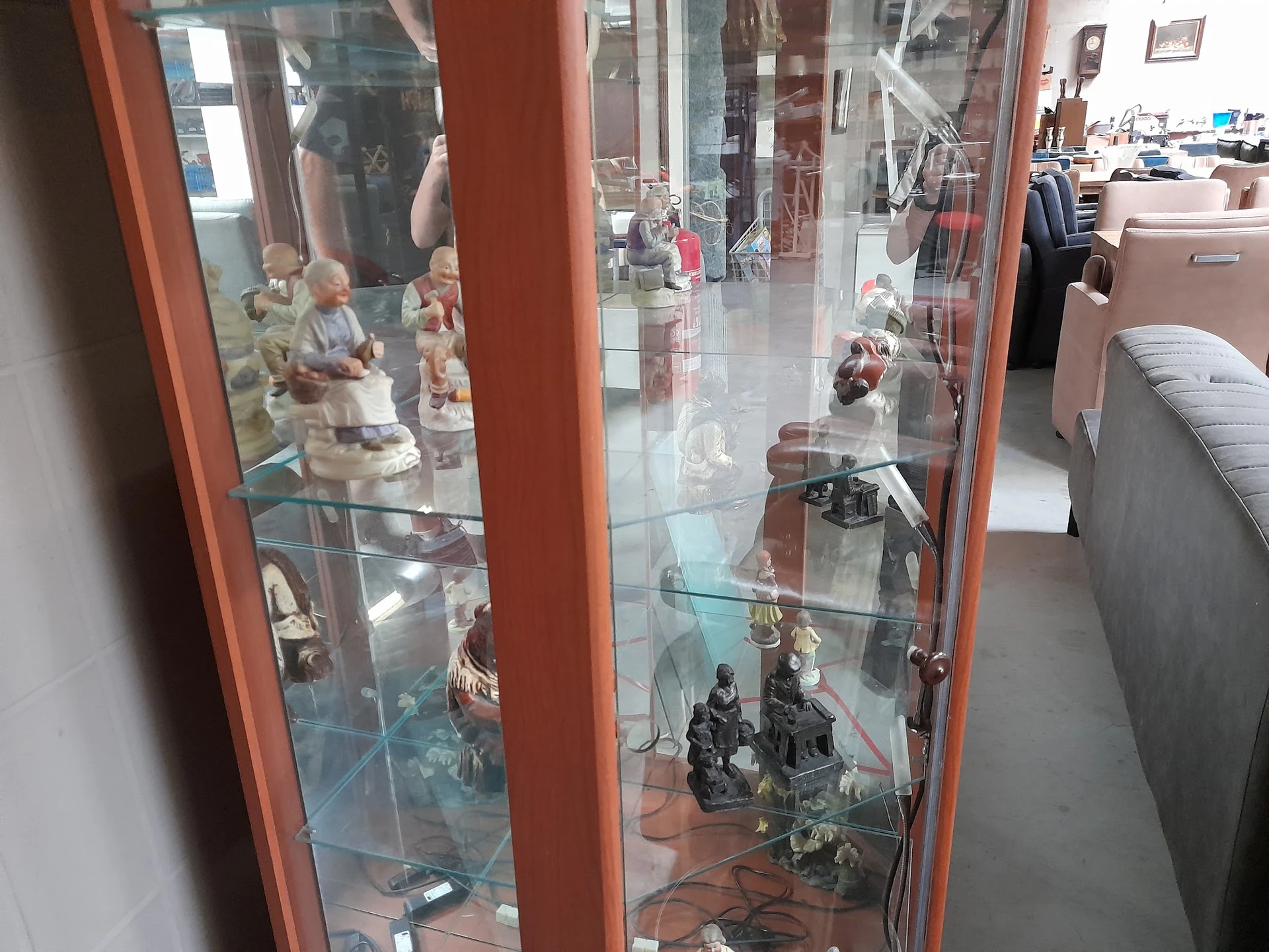 Glazen vitrinekast met verzameling decoratieve beeldjes en figuren