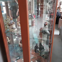Glazen vitrinekast met verzameling decoratieve beeldjes en figuren