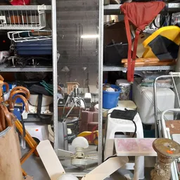 Overzicht van kringloopwinkel met stellingen vol diverse spullen, huishoudartikelen en kleding