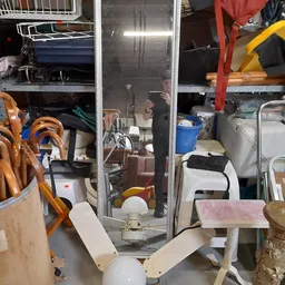 Volle stellingen en opgeslagen spullen in een kringloopwinkel, inclusief huishoudartikelen en meubels