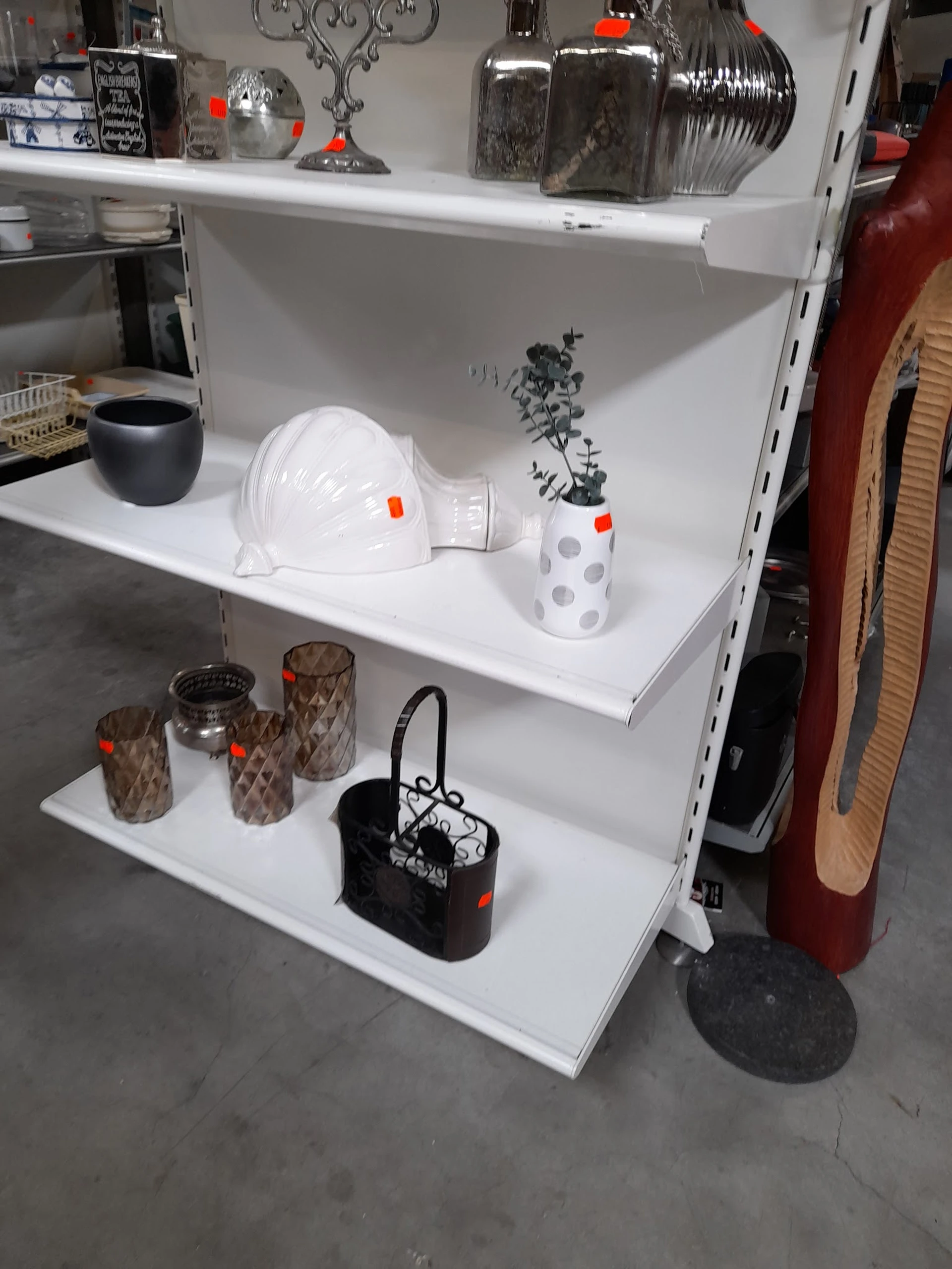 Witte stellingkasten met huishoudelijke artikelen: helm, plantenpot, kandelaar en handtas
