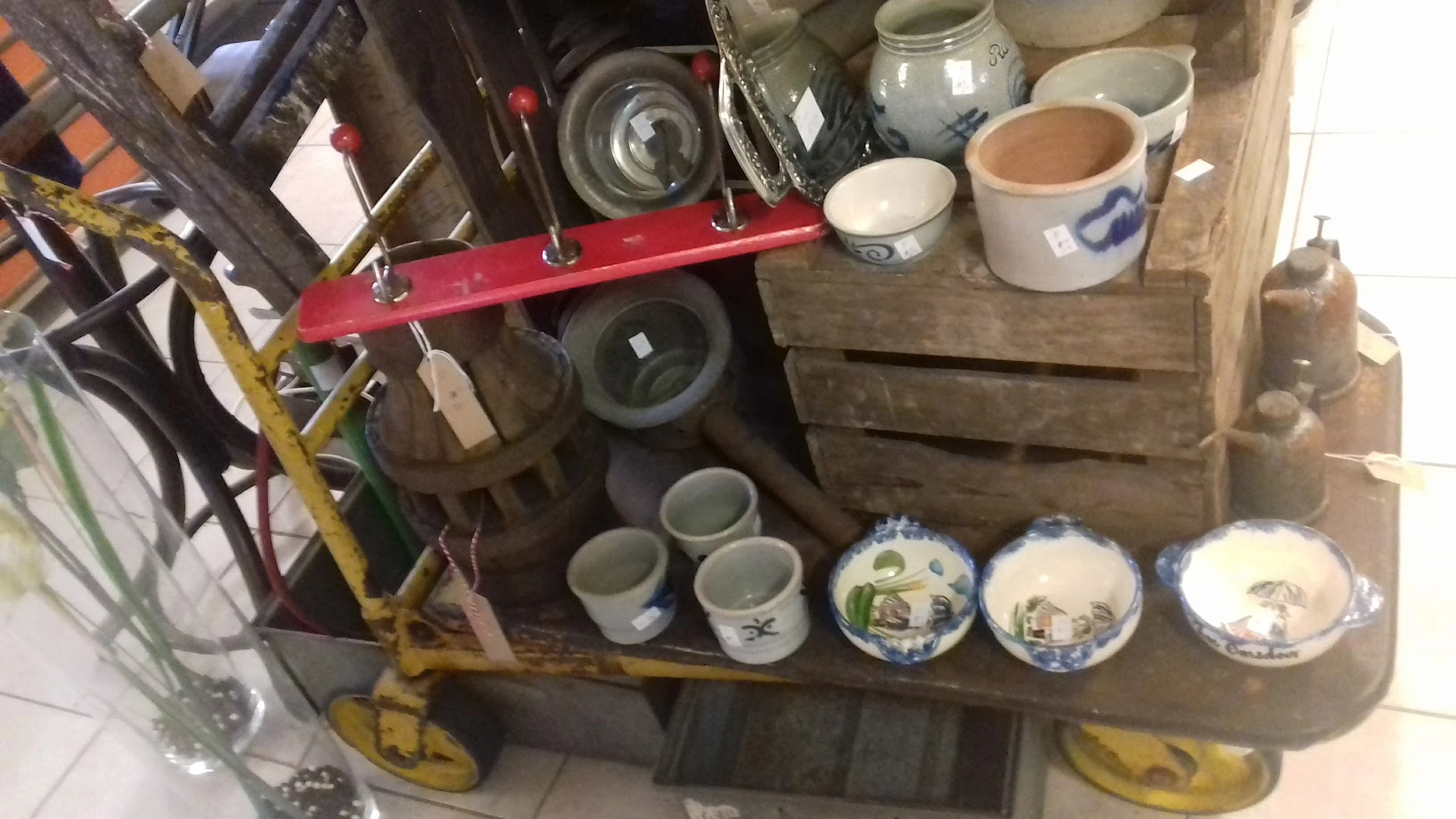 Houten stellingen met diverse servies, kopjes en decoratieve borden uitgestald