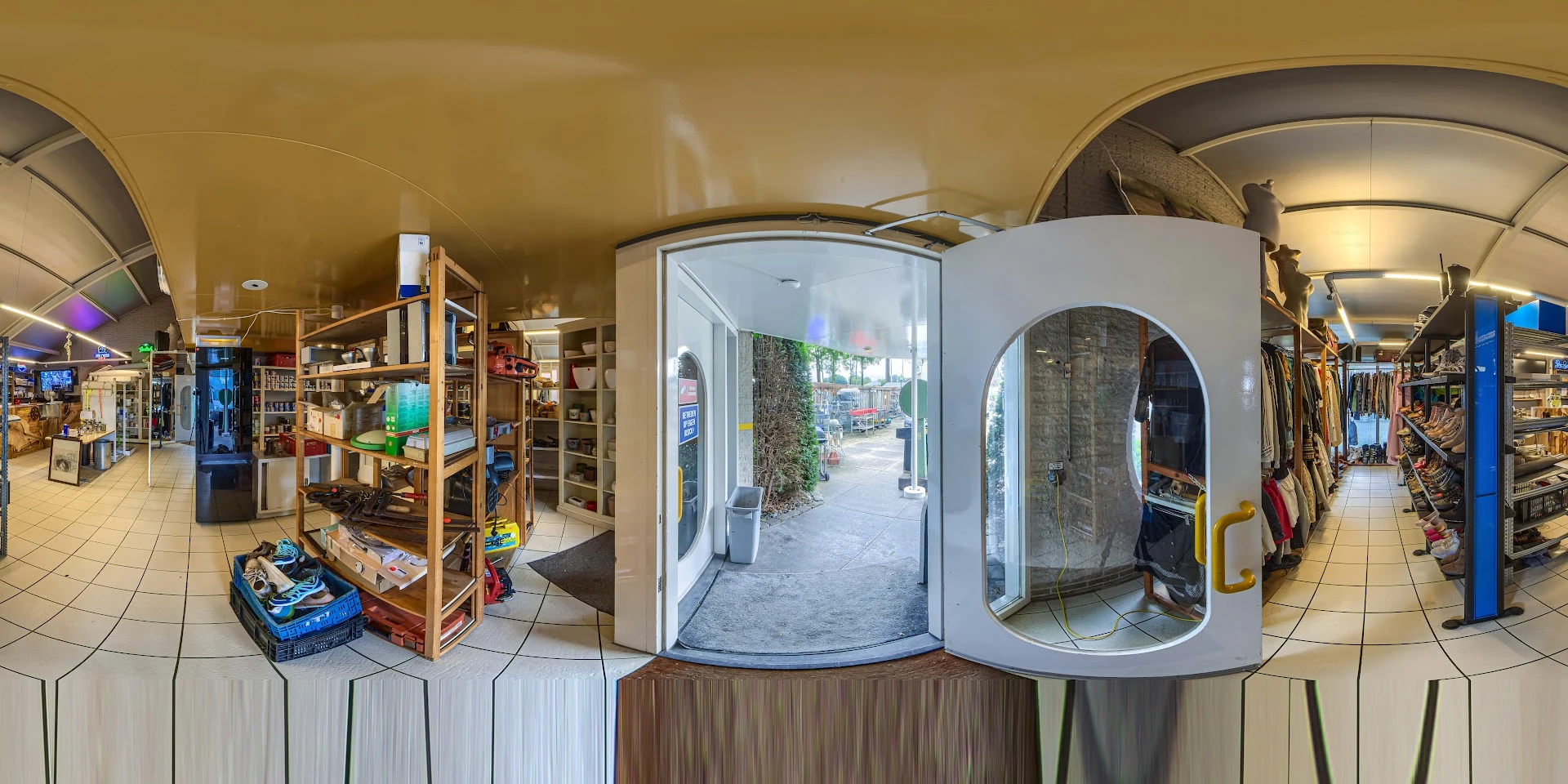 Winkelinterieur met stellingen, winkelrekken, uitstalling en zicht op straat buiten