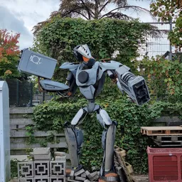 Groot wit en zwart robot speelgoed in een tuin met klimop begroeid hek