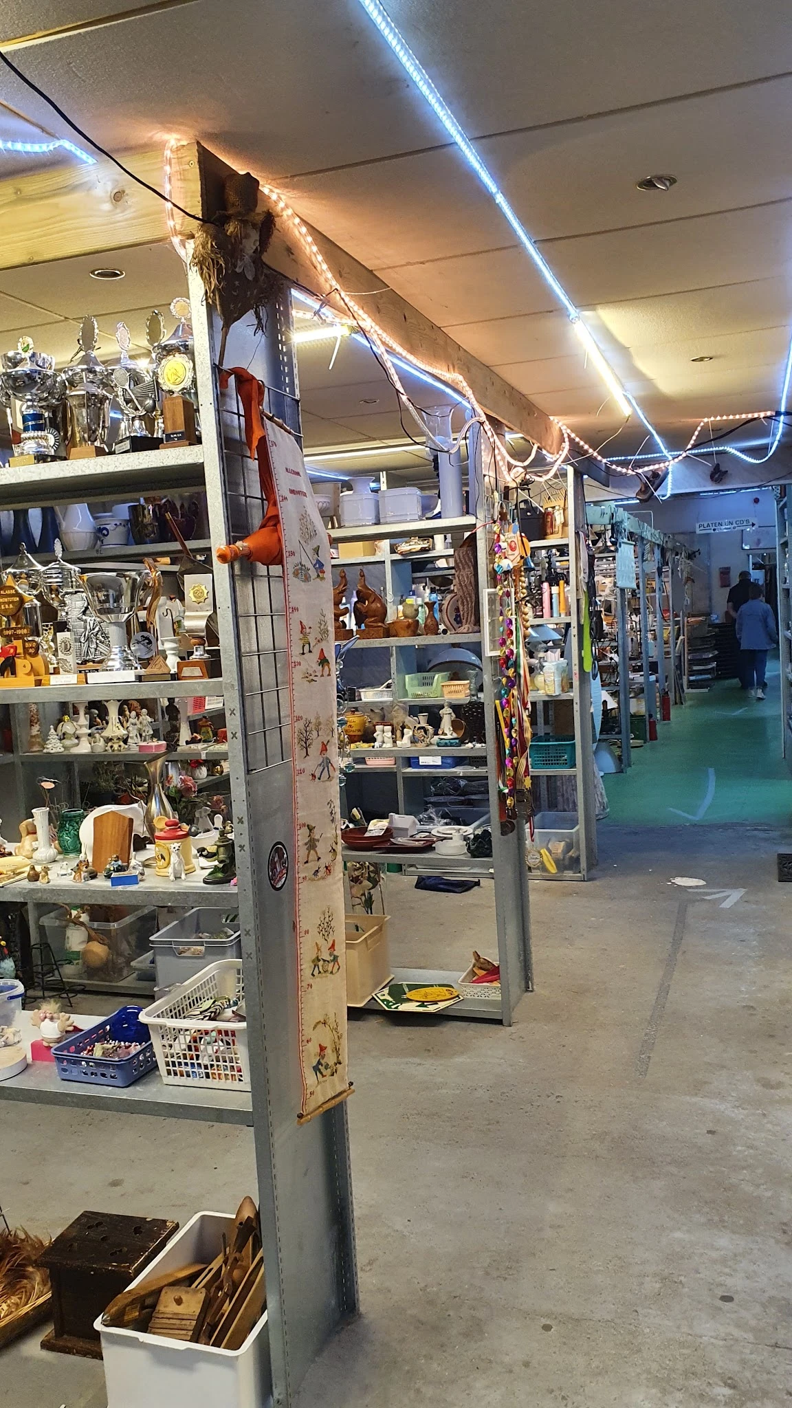 Winkelinterieur met diverse vitrines en stellingen vol spullen en decoratiestukken