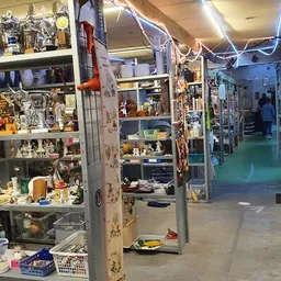 Winkelinterieur met diverse vitrines en stellingen vol spullen en decoratiestukken