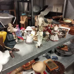Vitrinekast met verzameling decoratieve beeldjes en vintage items zoals dierenfiguren en porseleinen popjes
