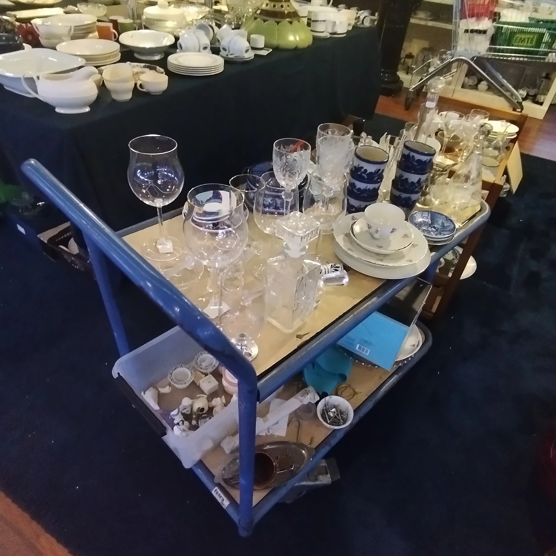 Tafelwagen met glas- en serviesgoed: wijnglazen, waterglazen, borden en blauwe bekers