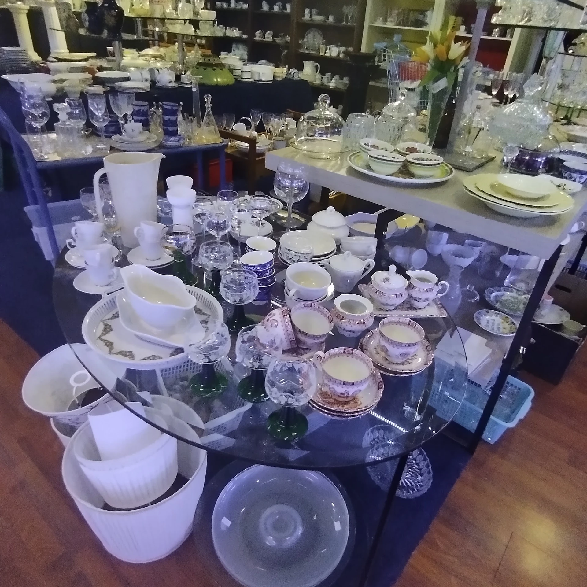 Uitgestalde serviesgoed en glazen op een donkere tafel in de winkel