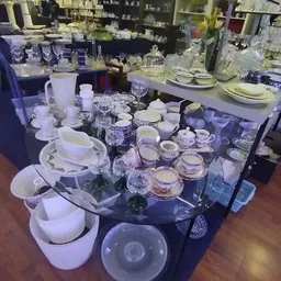 Uitgestalde serviesgoed en glazen op een donkere tafel in de winkel